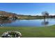 Picturesque golf course with a beautiful lake, small waterfall, and lush green landscape at 2327 W Firethorn Way, Anthem, AZ 85086