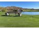 Beautiful golf course view with bench seating, lush grass, and serene lake at 2327 W Firethorn Way, Anthem, AZ 85086