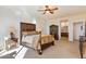 Main bedroom with a king-size bed, ceiling fan, and ensuite bathroom access at 2327 W Firethorn Way, Anthem, AZ 85086