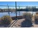 Outdoor tennis court with a covered seating area, enclosed by a secure fence at 2327 W Firethorn Way, Anthem, AZ 85086