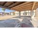 Cracked concrete parking area with covered carport and view of apartment buildings at 3605 W Bethany Home Rd # 10, Phoenix, AZ 85019