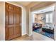 Entryway with wood door and view of cozy den with leather sofa at 3773 E Donald Dr, Phoenix, AZ 85050