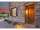 Elegant front door with stone surround and warm lighting at 3773 E Donald Dr, Phoenix, AZ 85050