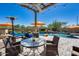 Covered patio with poolside seating and umbrellas at 3773 E Donald Dr, Phoenix, AZ 85050