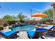 Inviting pool area with blue lounge chairs and orange umbrellas at 3773 E Donald Dr, Phoenix, AZ 85050
