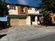 Two-story home with tan and orange exterior, two-car garage, and landscaped yard at 4818 W Ellis St, Laveen, AZ 85339