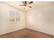 Bright bedroom with brown carpet, a window with blinds, and a ceiling fan at 524 N Leoma Ln, Chandler, AZ 85225