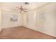 Well-lit bedroom with brown carpet, built-in shelves, and a ceiling fan at 524 N Leoma Ln, Chandler, AZ 85225