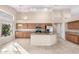 Kitchen boasts an island, wood cabinets, and granite countertops at 8630 W Melinda Ln, Peoria, AZ 85382