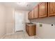 Laundry room with wooden cabinets and tiled floor at 8630 W Melinda Ln, Peoria, AZ 85382