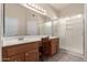 Bathroom with double vanity sinks, wood cabinets, a large mirror, and a walk-in shower at 9237 E Diamond Dr, Sun Lakes, AZ 85248