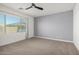 A bedroom with neutral walls, carpeted flooring, and large window offering natural light at 9658 E Tahoe Cir, Mesa, AZ 85212