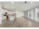 Open concept floor plan with island kitchen, stainless appliances, white cabinets, and a spacious living area with wood-look flooring at 9658 E Tahoe Cir, Mesa, AZ 85212
