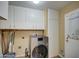 Bright laundry room with washer, dryer, and ample cabinet storage at 9909 W Newport Dr, Sun City, AZ 85351