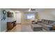 Living area with sectional sofa, large TV, and wood floors at 9909 W Newport Dr, Sun City, AZ 85351