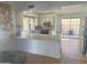 Bright kitchen with breakfast bar, granite countertops, and access to patio at 9992 E Carol Ave, Scottsdale, AZ 85258