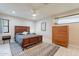 Spacious bedroom with a wooden bed frame, dresser, and ceiling fan at 1001 N Burk St, Gilbert, AZ 85234