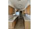 Long galley kitchen with wood cabinets and tile flooring at 10546 W Catalina Dr, Arizona City, AZ 85123