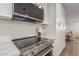 Stainless steel range and microwave in a bright white kitchen with marble backsplash at 1164 E Westchester Dr, Tempe, AZ 85283