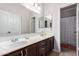 Bathroom with double sinks, dark wood cabinets, and a shower/tub combo at 1269 N Layman St, Gilbert, AZ 85233