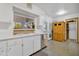 Kitchen features white cabinets, stainless steel sink, and wood storage at 13635 N 111Th Ave, Sun City, AZ 85351