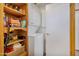 Stackable washer and dryer in a well-lit laundry room with storage shelves at 13635 N 111Th Ave, Sun City, AZ 85351