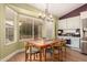 Kitchen dining area with wood table and chairs, and large windows at 14215 W Mountain Laurel Trl, Surprise, AZ 85374