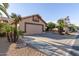 Tan house with a two-car garage and driveway at 14215 W Mountain Laurel Trl, Surprise, AZ 85374