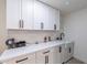 Laundry room with white cabinets, a farmhouse sink, and washer/dryer at 14241 N 54Th St, Scottsdale, AZ 85254