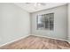 Simple bedroom with wood-look floors and a window with blinds at 14352 W Lamoille Dr, Surprise, AZ 85374