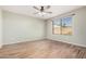 Bedroom with wood-look floors, ceiling fan, and large window at 14352 W Lamoille Dr, Surprise, AZ 85374