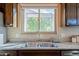 Kitchen sink and faucet with granite countertop and dark wood cabinets at 14352 W Lamoille Dr, Surprise, AZ 85374