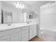 Bright bathroom featuring double sinks, a large mirror, modern fixtures, and tile flooring at 14644 W Sand Hills Rd, Surprise, AZ 85387