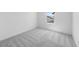 Bright bedroom with gray carpet, white walls, and a window letting in natural light at 14644 W Sand Hills Rd, Surprise, AZ 85387