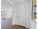 Inviting entryway with wood-look tile, natural light, and a white front door at 14644 W Sand Hills Rd, Surprise, AZ 85387