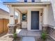 Charming front porch with stone-base columns and a stylish blue front door at 14644 W Sand Hills Rd, Surprise, AZ 85387