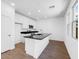 Bright kitchen with white cabinets, granite counters, a kitchen island, and wood-look floors at 14644 W Sand Hills Rd, Surprise, AZ 85387