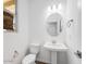 Bright powder room features a pedestal sink, oval mirror, and neutral color palette at 14644 W Sand Hills Rd, Surprise, AZ 85387