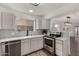 Modern kitchen with white cabinets, stainless steel appliances, and quartz countertops at 1506 E Topeka Dr, Phoenix, AZ 85024