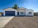 Newly constructed home with a modern design, two-car garage, and gravel driveway at 15235 S Country Club Dr, Arizona City, AZ 85123