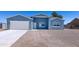 Newly built home with blue exterior, white garage door, and gravel driveway at 15245 S Country Club Dr, Arizona City, AZ 85123