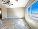 Bright living room with large window, wood-look tile, and ceiling fan at 15245 S Country Club Dr, Arizona City, AZ 85123