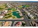 Aerial view of a community with golf course, lake, and residential homes at 15437 W Domingo Ln, Sun City West, AZ 85375