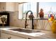 White kitchen with geometric backsplash, gold fixtures, and a large sink at 15437 W Domingo Ln, Sun City West, AZ 85375