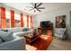 Open living space with L-shaped sectional sofa, orange rug, and wood accent wall at 15437 W Domingo Ln, Sun City West, AZ 85375