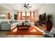 Bright living room with L-shaped sofa, orange rug, and a fireplace at 15437 W Domingo Ln, Sun City West, AZ 85375