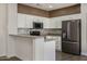 Updated kitchen featuring white cabinets and mosaic backsplash at 15513 W Coral Pointe Dr, Surprise, AZ 85374