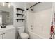 Clean bathroom with tub shower and floating shelves at 15720 W Crocus Dr, Surprise, AZ 85379