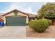 Tan house with a green garage door and landscaped front yard at 15720 W Crocus Dr, Surprise, AZ 85379