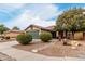 Tan house with a green garage door and stone pathway at 15720 W Crocus Dr, Surprise, AZ 85379